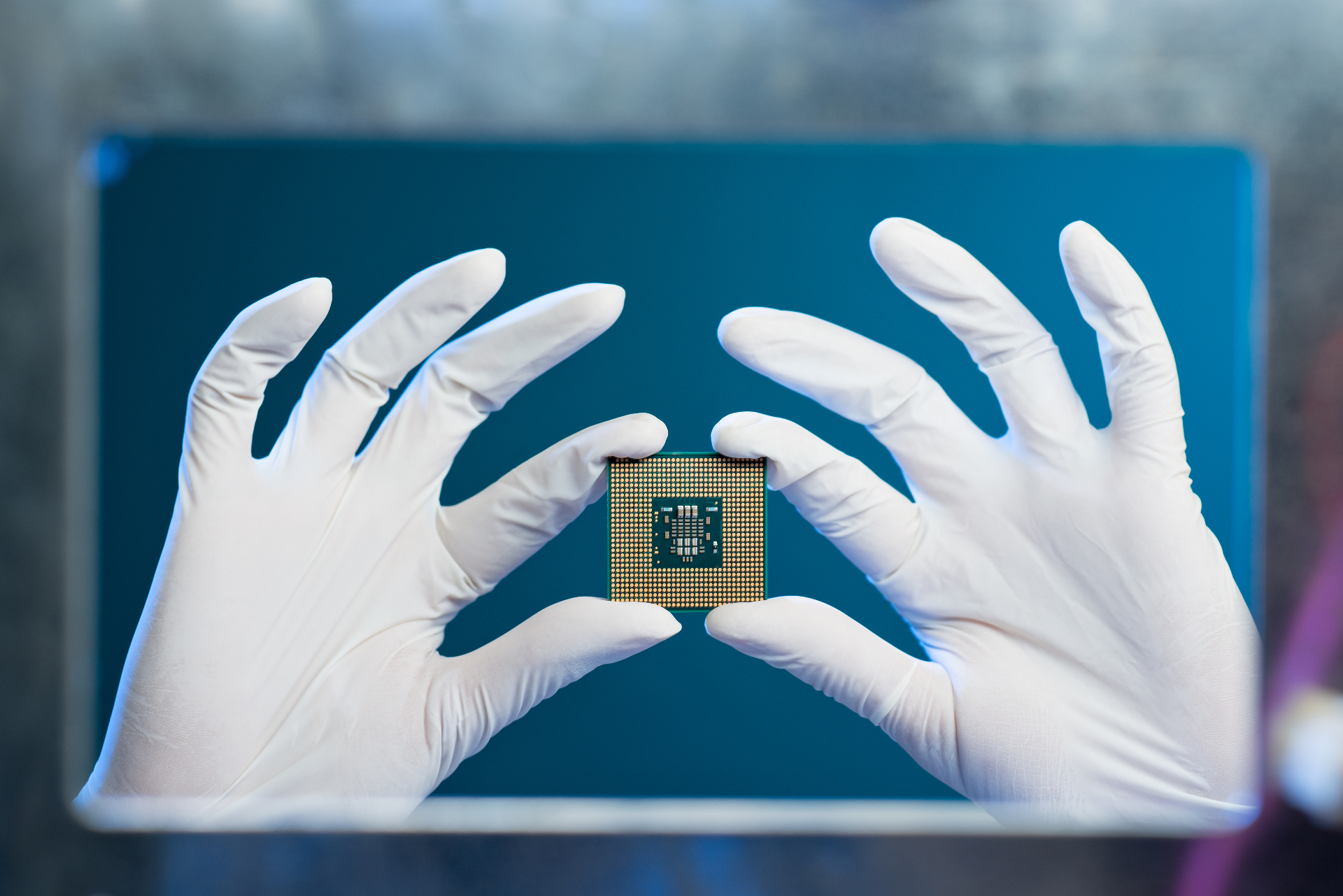 Gloved hands holding a silicon processor chip
